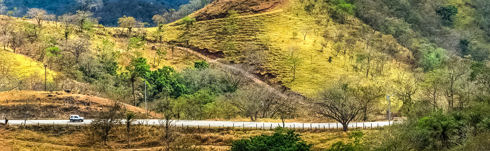 Bil kører gennem bakkerne i Guanacaste, Costa Rica