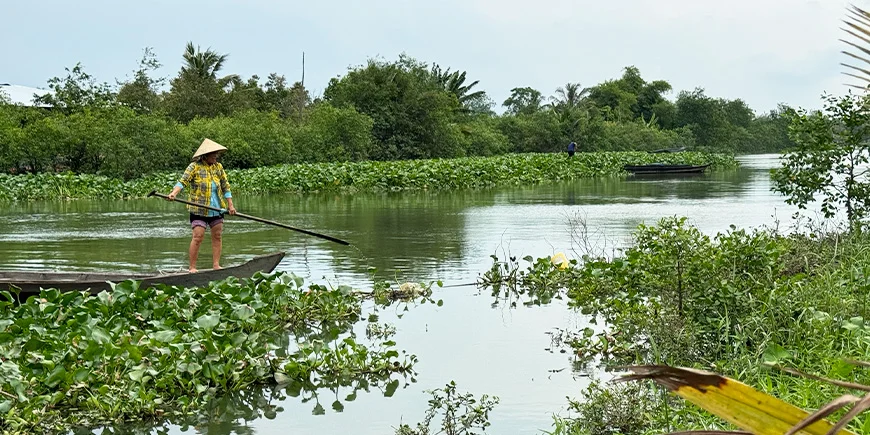 Kvinde sejler i Mekong-deltaet