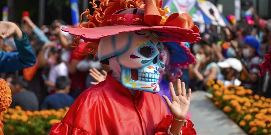 Person i udklædning under parade på De Dødes Dag i Mexico City