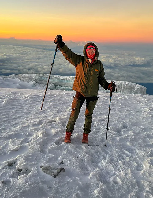 Cat fra TourCompass står på toppen af Kilimanjaro ved solopgang
