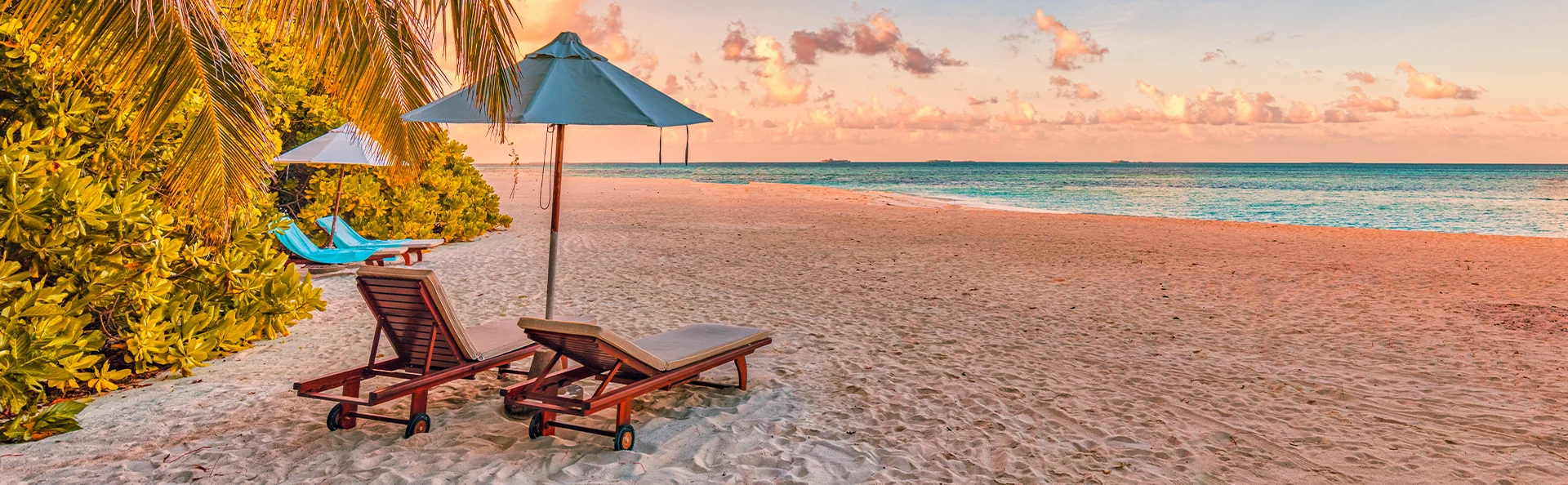 Liggestole på tropisk strand på Mauritius ved solnedgang