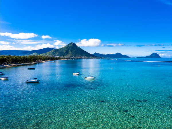 Flic en Flc-stranden på Mauritius med udsigt til smukt vand og grønne bjerge 
