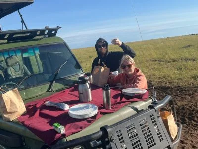 To personer spiser morgenmad på safaribilen