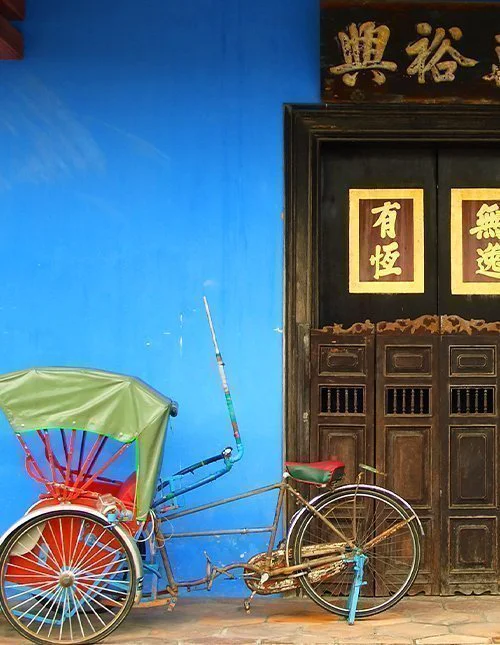 Blå kinesisk husdør med rickshaw i Singapore